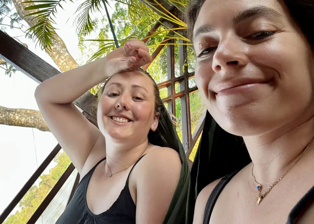Laos or Vietnam: How to Choose the Best Country for Your Trip 26 Two girls smiling lay in hammocks on the balcony of their bungalow in Don Det