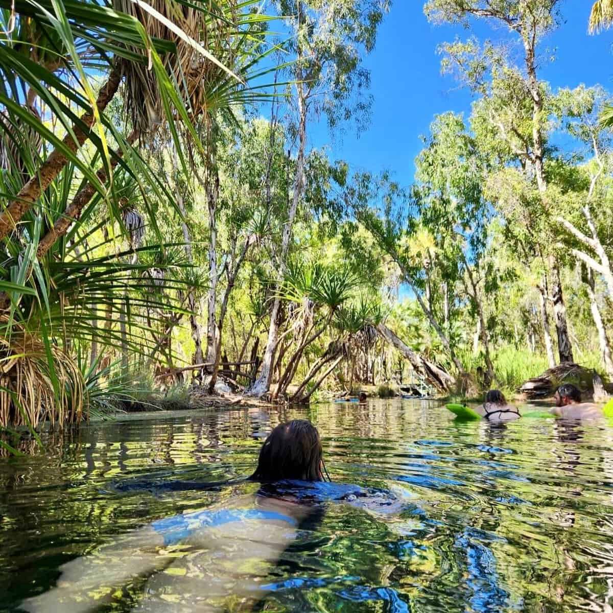 About The Lavender Travelers 2 A girl is swimming in a lagoon surrounded by lush green vegetation