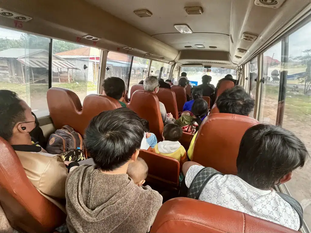 People on public transport in Laos. There are people sat in the aisles of the bus from Huay Xai to Luang Namtha