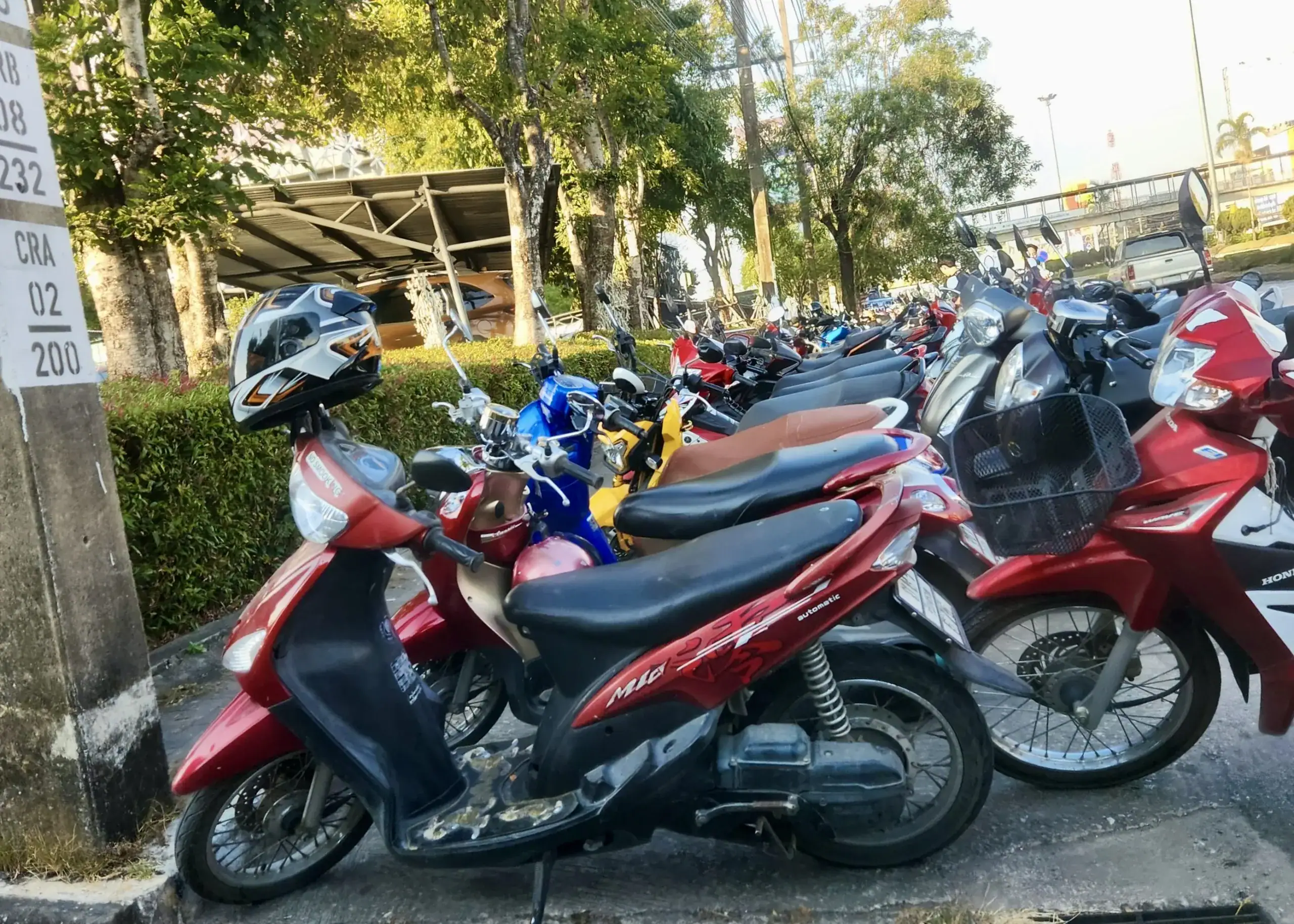 Red motorbikes lined up outside a bike hire shop in Laos