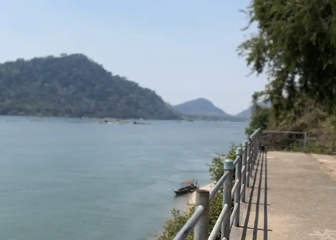 Where to Stay in Don Det & the 4000 Islands, Laos 3 A hazy view over the Mekong on the Laos side in Don Det overlooking the border of Cambodia. The water is calm and blue with hilly green islands dotting the water.