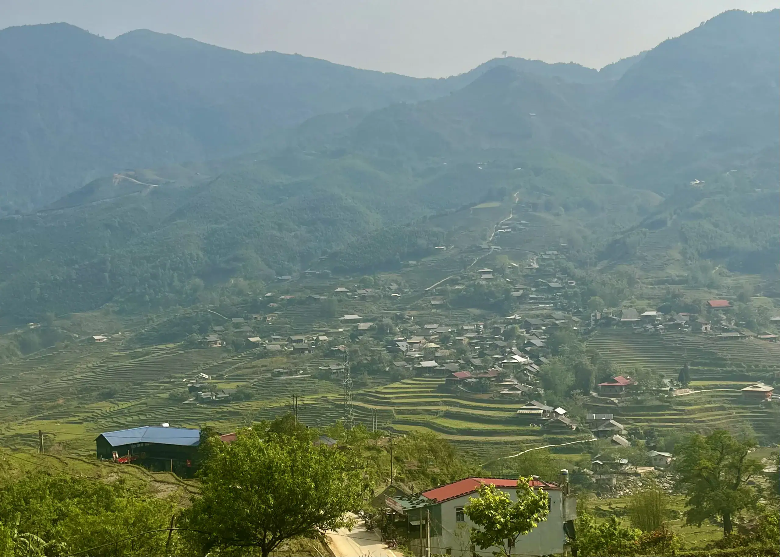 The Best Homestay in Sapa: A Beginner’s Guide to Homestays 8 Lush terraced farmland and mountain village in a scenic rural landscape.