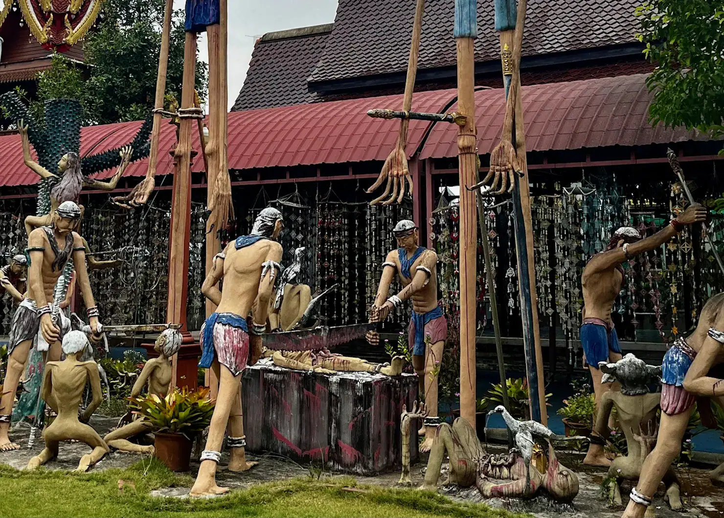 A display at Wat Mae End in Chiang Dao. There are 10 statues of humans, all commiting acts of violence against other statues. Such as sawing a body, beheading, eaten by animals.