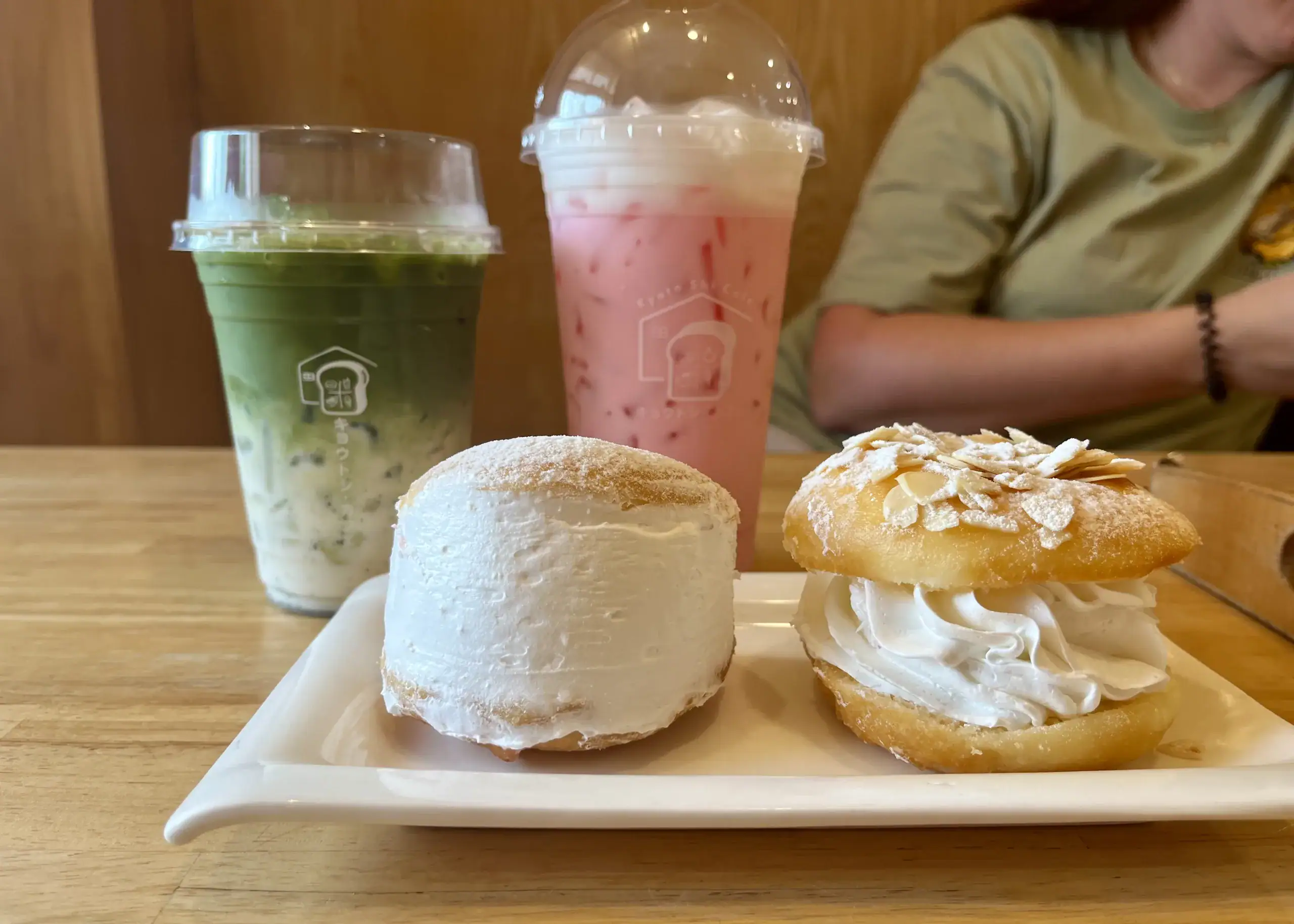 Chiang Mai or Chiang Rai: Which Is Better? 4 The picture shows food and drink from Kyoto Shi in Chiang Rai. The drinks are pink and green and there are two cream cakes with almonds on top