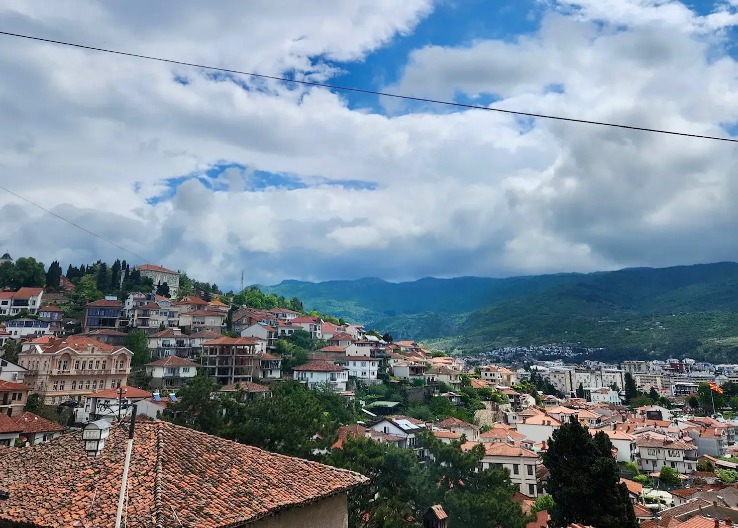 9 Exciting Things To Do in Ohrid, North Macedonia 8 Orange rooves line the hills surrounding Ohrid. With a cloudy sky and green mountains in the background