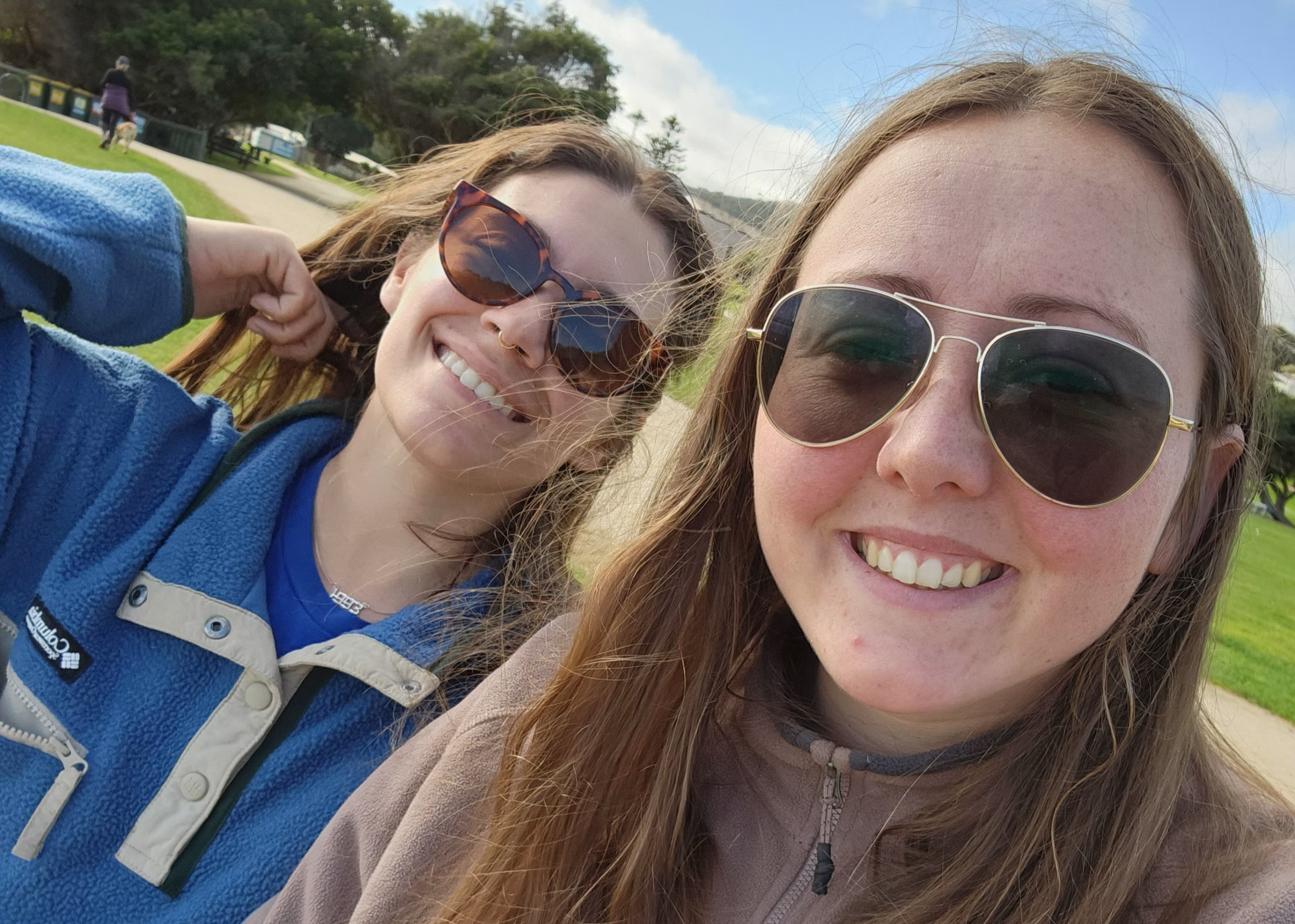 43 Thoughtful and Practical Gift Ideas for Budget Travelers 11 A picture of two girls smiling wearing sunglasses. They both have dark hair and one wears a blue fleece and the other wears a purple fleece