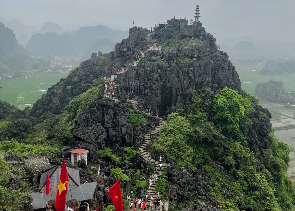Laos or Vietnam: How to Choose the Best Country for Your Trip 5 The view from the top of Mua Cave viewpoint. You can see the path snaking up the mountain on the opposite side and the mountains and rice fields around.