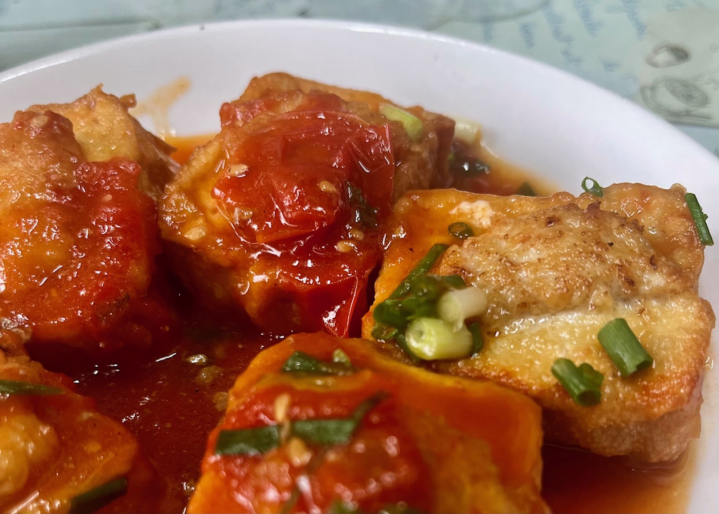 Things to See in Ninh Binh: 10+ Must-Visit Attractions for Budget Travelers 10 A close up of fried tofu stuffed with meat and covered in tomato sauce is sitting on a white plate.