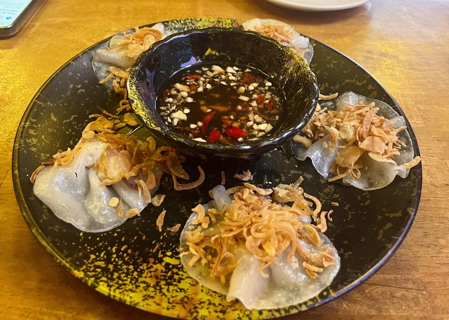 Hoi An Itinerary: 3 Days of Food & Lantern-Lit Charm 5 A plate of food at a restaurant in Hoi An. There are five dumplings topped with pork floss circled around a bowl of chilli sauce