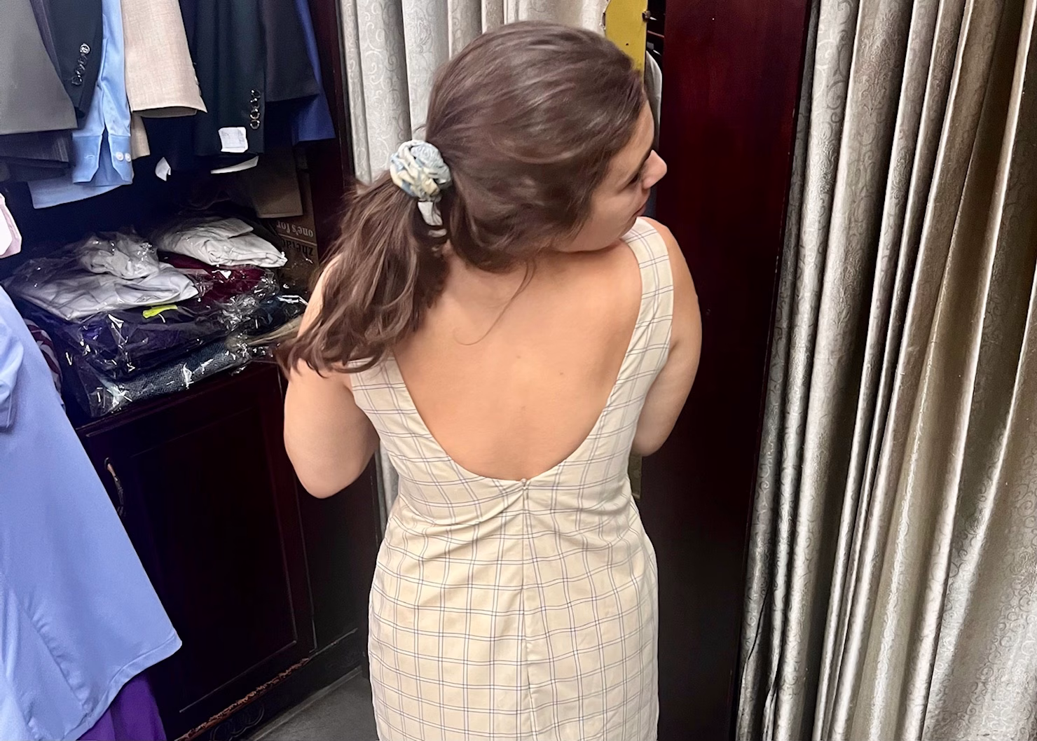 Hoi An Itinerary: 3 Days of Food & Lantern-Lit Charm 7 A girl is wearing a beige dress and looking over her shoulder for what it looks like in the mirror