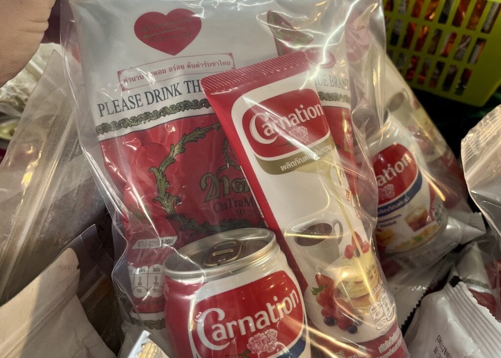 Our Honest Grandma’s Home Cooking School Review 5 A close up of thai tea mix, condensed milk, and evaporated milk (all Carnation brand) that are grouped in a plastic bag to sell as a set.