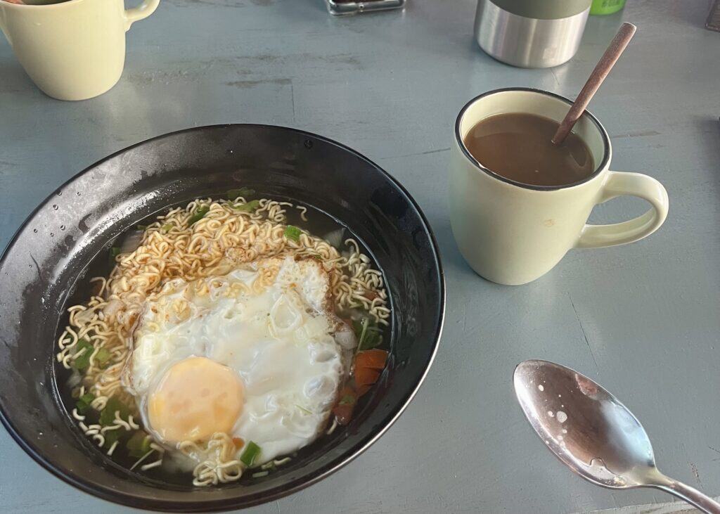 Where to Stay in Luang Prabang: 4 Best Areas for First-Time Visitors 4 A breakfast of noodles with an egg and coffee at Funny Riverside Backpackers in Luang Prabang, Laos.
