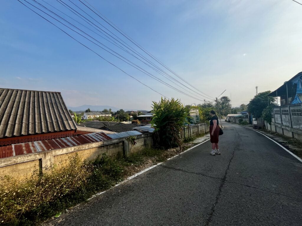 Where to Stay in Chiang Dao: 3 Best Areas & Top Picks 3 A woman is walking down the road just off the main road in Chiang Dao Thailand.