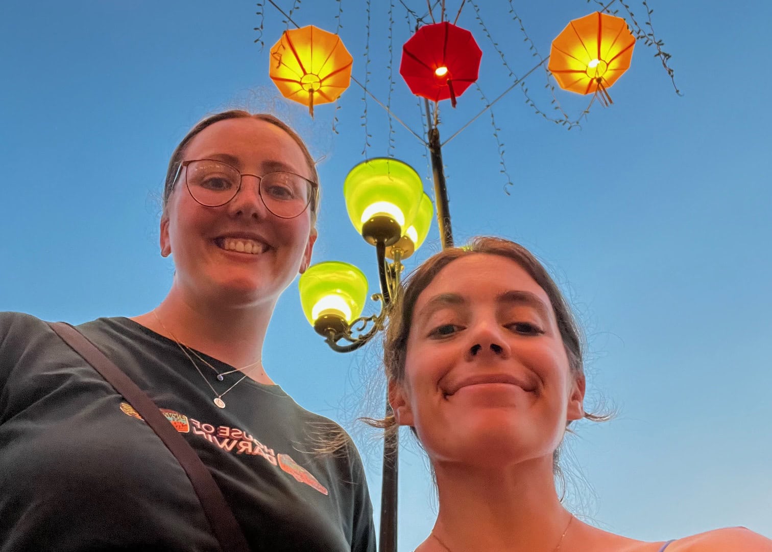 Where to Stay in Hoi An (3 Best Areas + Stays We’d Book) 7 Two smiling women enjoying the vibrant lantern display in Hoi An, Vietnam.